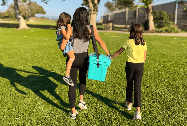 Mother walking with her two daughters carrying a teal Viva Cubix rotomolded cooler
