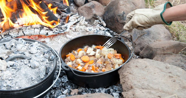 Person cooking a stew in a Dutch oven