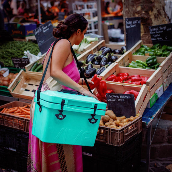 woman using shoulder strap to carry a cooler on her shoulder